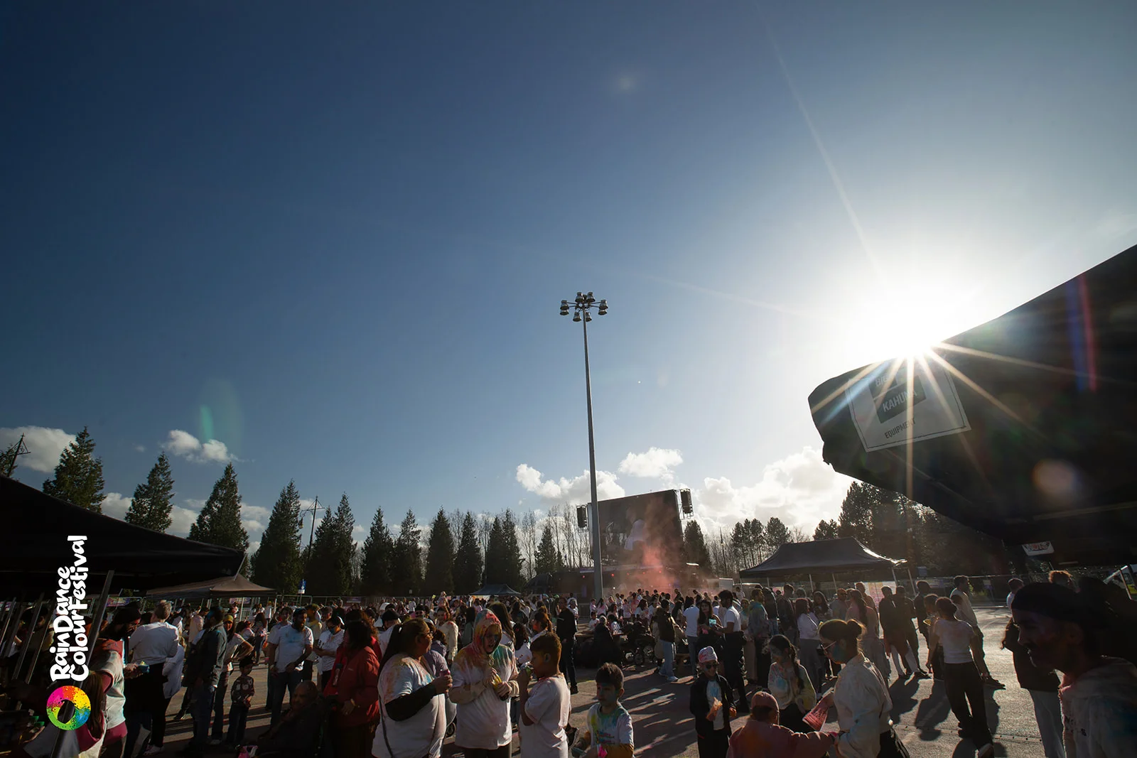 Crowd throwing colour powder at sunset